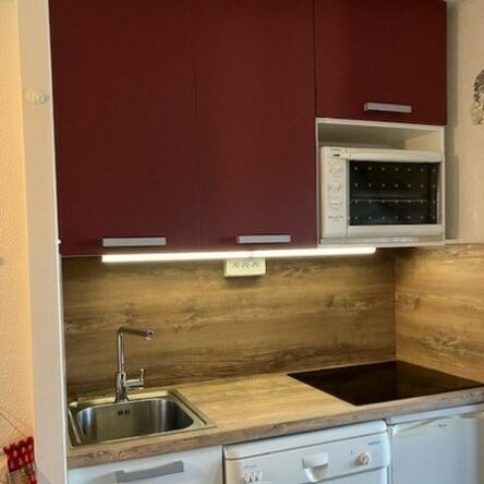 cuisine rouge et blanc PET mat anti salissure grands meubles suspendus niche pour four plan de travail et crédence type vieux bois HPL cuisiniste Aime La Plagne